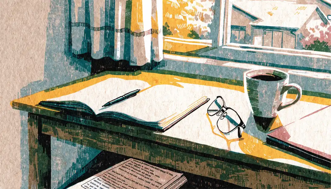 Home office desk with notebook, glasses, and closed laptop in soft daylight.